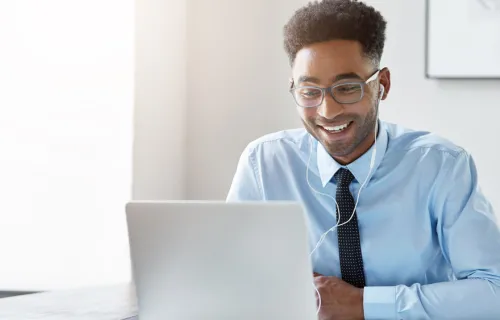 Une personne en train de sourire devant son ordinateur