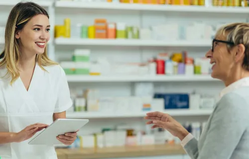 customer and pharmacist talking at a pharmacy counter