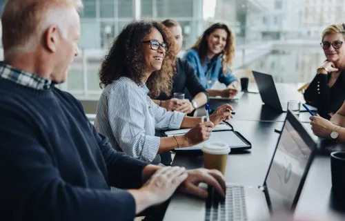 Cyber consultants smiling sat around conference table