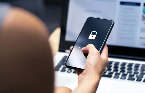 Person looking at a smart phone showing a locked icon