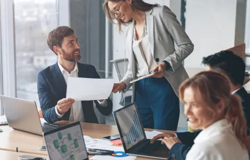 deux consultants se transmettant un document