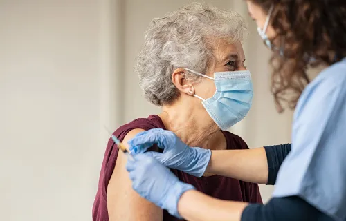 doctor giving vaccine to senior woman