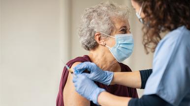 doctor giving vaccine to senior woman