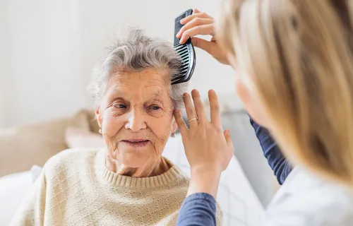 Elderly health patient having hair combed
