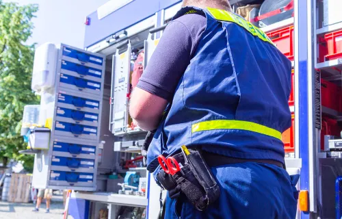 Techniker arbeitet an elektrischen Anlagen in einem Servicefahrzeug