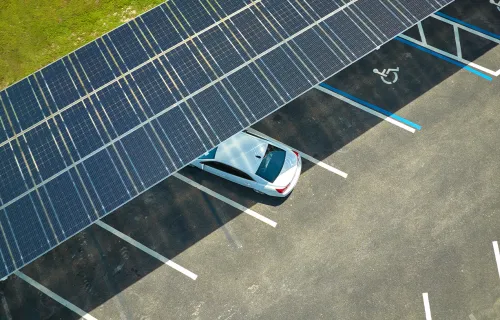 une voiture garée sous le toit d'un panneau solaire dans un parking public