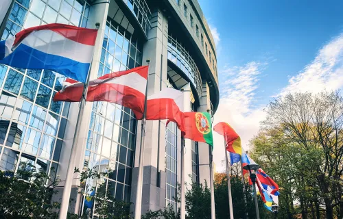 Plusieurs drapeaux internationaux agitant devant un bâtiment modern