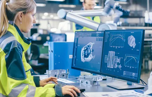 Female factory worker looking at computer screen - Digital twin 