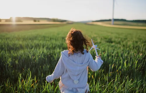 Une jeune fille dans un champs regardant au loin