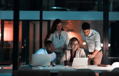 Four people collaborating on laptops