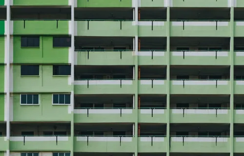 Front view of an old apartment complex green exterior facade