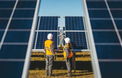 Two workers operating on solar panels