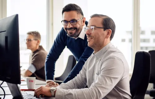 Two GCC professionals looking at a computer screen 