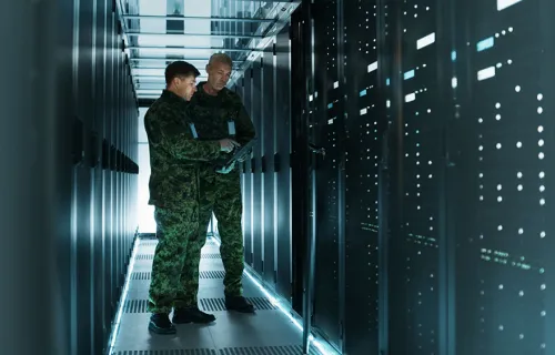 Två militärklädda personer står i en datorhall