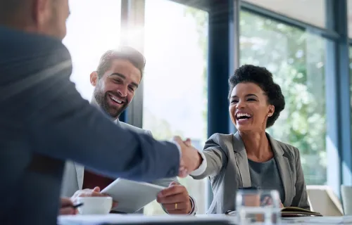 A group shaking hands across a table