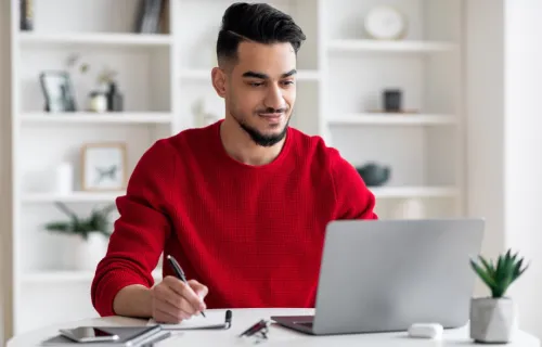 guy with beard works on laptop
