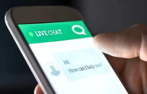 Main tenant un téléphone cellulaire utilisant un chatbot