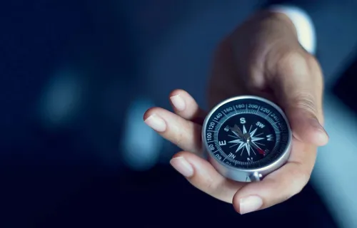 Hand holding a compass
