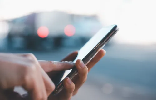 Closeup of hands holding and scrolling through mobile phone