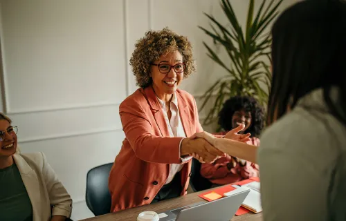woman shaking the hand of business colleague