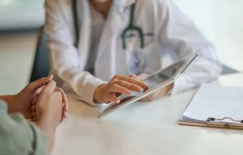 doctor refers to patient health data on tablet