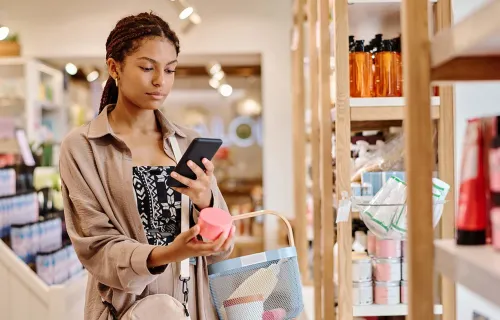 Person looks at mobile device whilst shopping