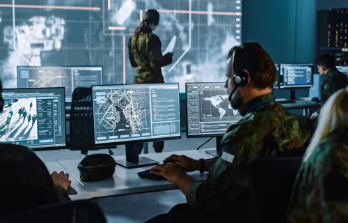 Military personnel analysing data on a computer