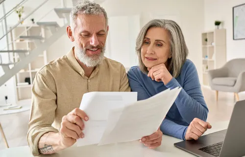 deux personnes regardant des documents d'assurance-vie et de retraite
