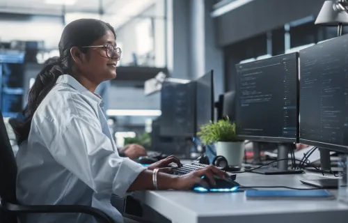 Woman working on multiple screens