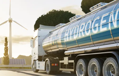 a truck transporting hydrogen with a wind turbine in the background