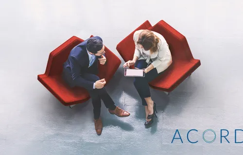 Male and female business people sitting side by side having a discussion
