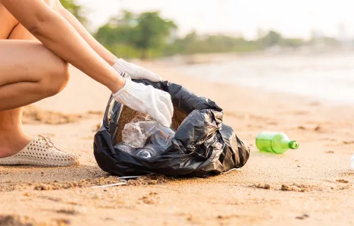 Person collecting trash on beach