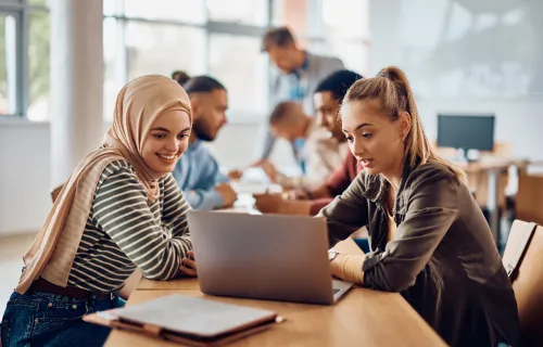 two women collaborating on a laptop