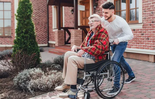 Young person pushing elderly person wheelchair