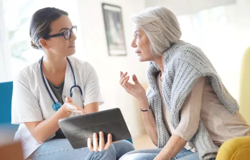 Health care professional talking to an elderly patient