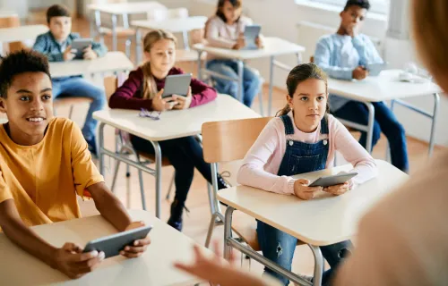 children using tablets in a classroom
