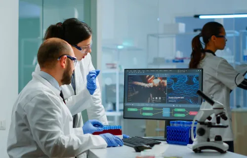 Two scientists working together at a workstation