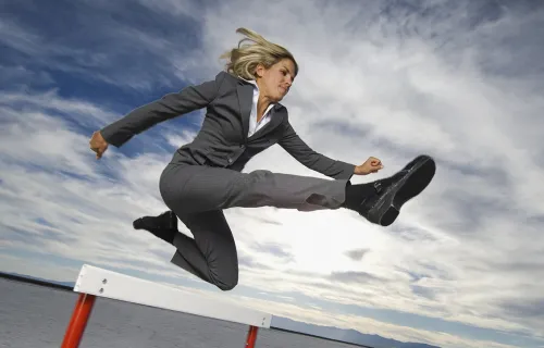 businesswoman jumping a hurdle