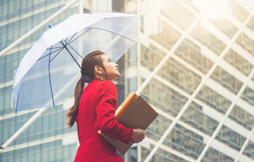 Femme dans un quartier d'affaires qui tient un parapluie