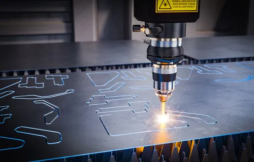 Närbild av en industriell laserskärare som skär ut former i en metallplåt. Gnistor syns vid…