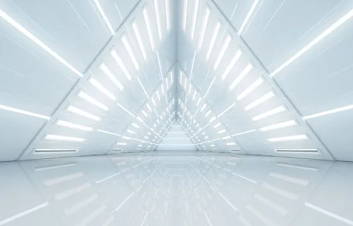 Inside of futuristic white building looking into a tunnel shaped like a triangle