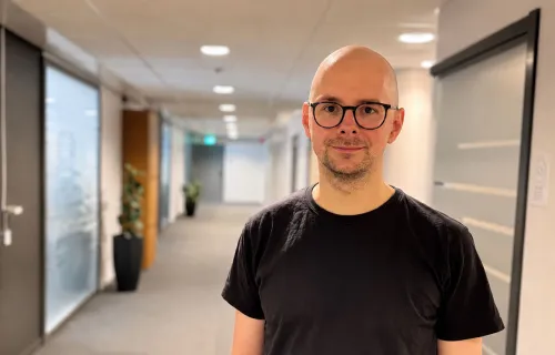 Porträttbild på Jonas Ek Eriksson framför en kontorskorridor