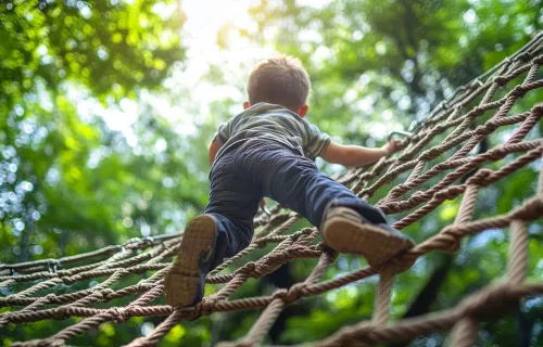 Junge klettert auf einem Netz-Klettergerüst