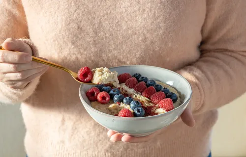 Raisio, a person holding a porrige bowl with fresh berries