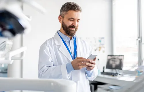 Läkare som håller i en mobiltelefon
