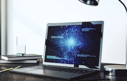 Ein Laptop steht auf einem Tisch und zeigt ein Cyber Bild an