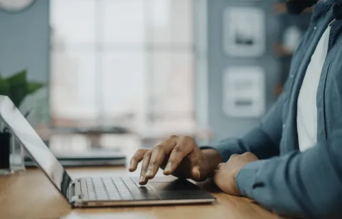 a man uses a laptop, representing CGI’s virtual learning support