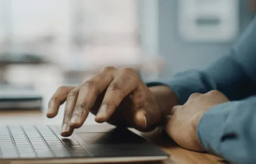 a man uses a laptop, representing CGI’s virtual learning support