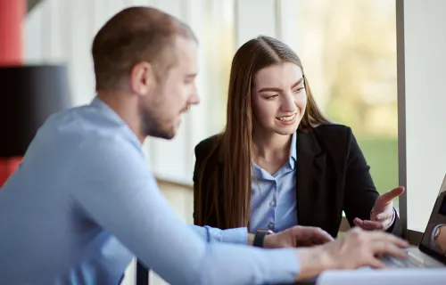 Dame og herre som jobber sammen på pc