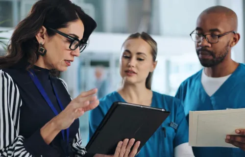 Kuvituskuva: Terveysalan ammattilaiset katsovat taloudenhallintajärjestelmää tabletilta